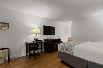 a bedroom with a bed and a desk with a television at Americas Best Value Inn Orlando, FL in Orlando