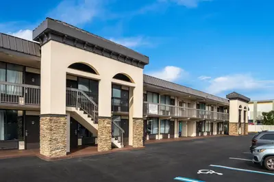a row of apartment buildings with a parking lot at Americas Best Value Inn Orlando, FL in Orlando
