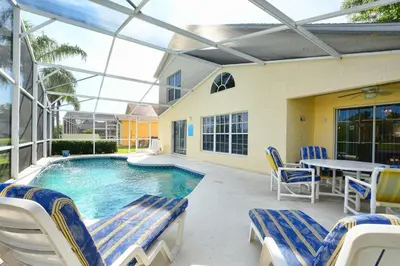 a patio with a pool and chairs and a table at Mickey's Lake Villa in Orlando