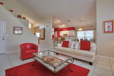 a living room with a couch and a red chair at Mickey's Lake Villa in Orlando