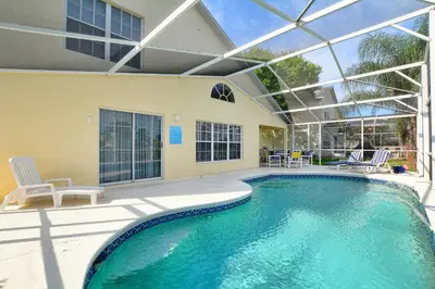 a swimming pool with a glass ceiling and a patio at Mickey's Lake Villa in Orlando