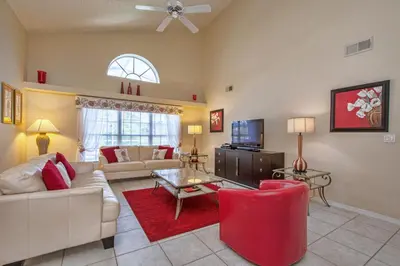 a living room with a couch and a tv at Mickey's Lake Villa in Orlando