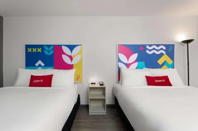 two beds sitting next to each other in a room at Baymont by Wyndham Orlando North Millenia in Orlando