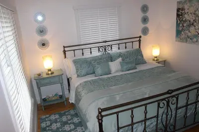 a bedroom with a large bed with two lamps on it at The Shed in Sanford