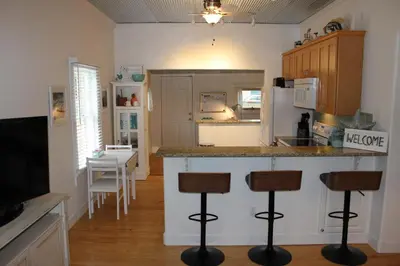 a kitchen with a counter and stools in a room at The Shed in Sanford