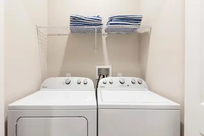 a laundry room with two washing machines and towels at Summerville Vacation Resort in Orlando