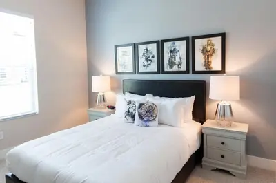 a bedroom with a white bed with three pictures on the wall at Summerville Vacation Resort in Orlando