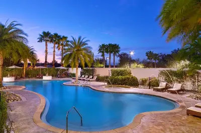 a swimming pool with palm trees and lounge chairs at The Westin Lake Mary, Orlando North in Lake Mary