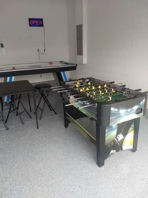 a ping pong table sitting in a room with a table at Luxury Disney Dreams Home with Pool, Spa & Game Room in Orlando