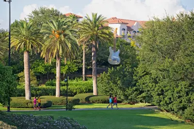 a group of people walking in a park with palm trees at Universal's Hard Rock Hotel® in Orlando