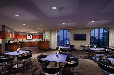 a dining room with tables and chairs and windows at Universal's Hard Rock Hotel® in Orlando