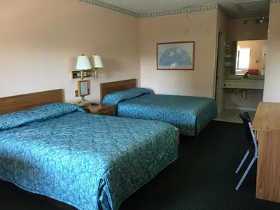 two beds in a hotel room with blue sheets at Flamingo Inn in Kissimmee
