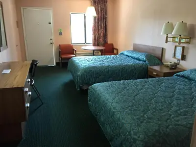 a hotel room with two beds and a table at Flamingo Inn in Kissimmee