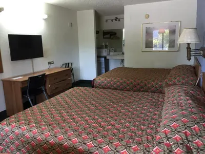 a hotel room with a bed and a desk at Flamingo Inn in Kissimmee