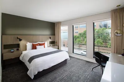 a bedroom with a large bed and a large window at The Delaney Hotel in Orlando