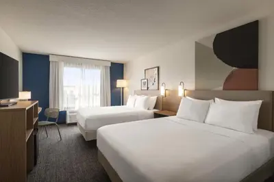 a hotel room with two beds and a television at Spark by Hilton Orlando Universal Boulevard in Orlando