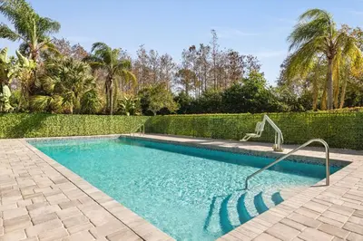 a swimming pool in a yard with a hedge at Spark by Hilton Orlando Universal Boulevard in Orlando
