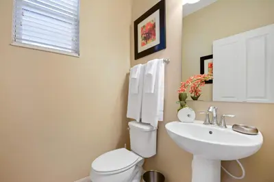 a bathroom with a white toilet and a sink at Four Bedrooms Townhome 5126K in Kissimmee