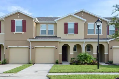 a house with a driveway and a street light at Four Bedrooms Townhouse 5102 in Kissimmee