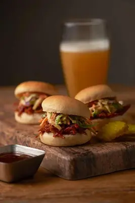 three sandwiches on a cutting board with a glass of beer at Hyatt Place Lake Mary/Orlando North in Lake Mary