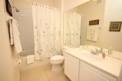 a white bathroom with a toilet and a sink at Shoreway House #231533 in Orlando