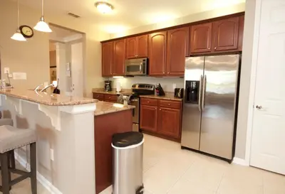 a kitchen with wooden cabinets and a stainless steel refrigerator at Cayview Condo #231536 in Orlando