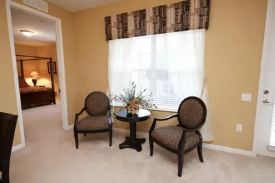 a living room with two chairs and a table and a window at Cayview House #231539 in Orlando