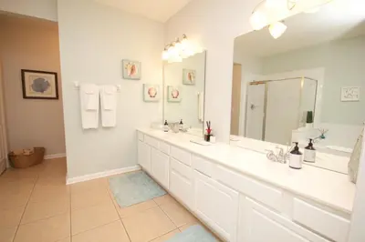 a bathroom with two sinks and a large mirror at Shoreway Condo #231521 in Orlando