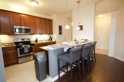 a kitchen with a kitchen island with bar stools at Shoreway House #231523 in Orlando