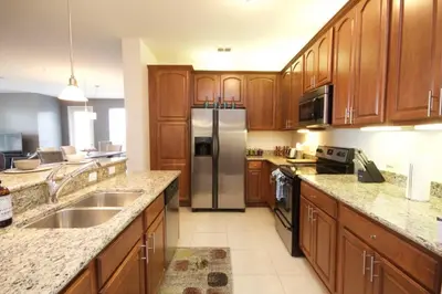 a kitchen with wooden cabinets and a stainless steel refrigerator at Shoreway House #231523 in Orlando
