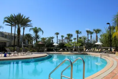 a swimming pool at a resort with palm trees at Shoreway House #231523 in Orlando