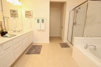a bathroom with two sinks and a tub and a shower at Shoreway Condo #231531 in Orlando