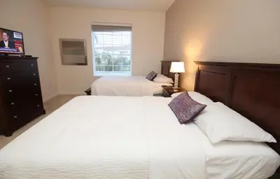a bedroom with two beds and a television in it at Shoreway Condo #231531 in Orlando