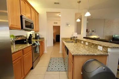 a kitchen with wooden cabinets and granite counter tops at Shoreway Condo #231531 in Orlando