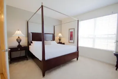 a bedroom with a canopy bed and a window at Shoreway Condo #231524 in Orlando