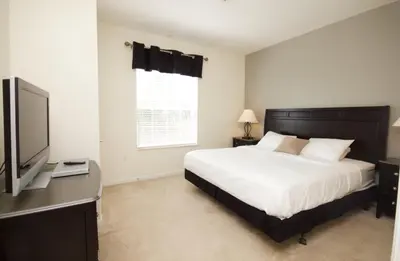 a bedroom with a bed and a flat screen tv at Shoreway Condo #231524 in Orlando