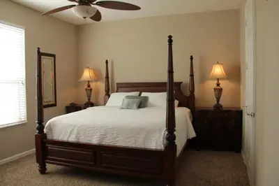 a bedroom with a bed with two lamps and a fan at Shoreway Condo #231520 in Orlando