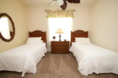 two beds in a room with a mirror and a window at Shoreway Condo #231520 in Orlando