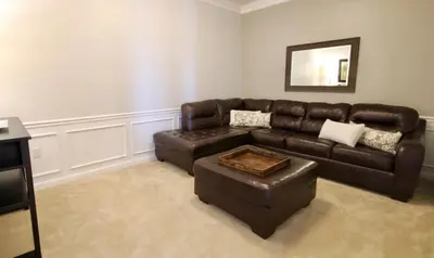 a living room with a brown leather couch and stool at Cayview Condo #231541 in Orlando