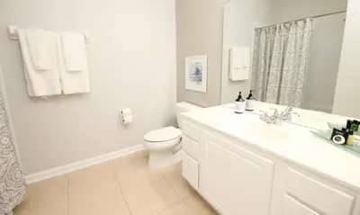 a white bathroom with a toilet and a sink at Cayview Condo #231541 in Orlando