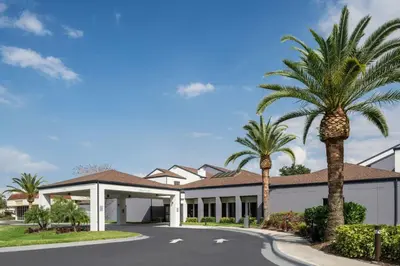 a house with palm trees in front of it at Courtyard by Marriott Orlando Airport in Orlando