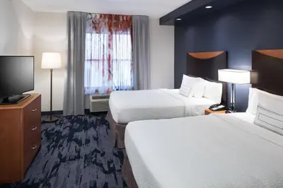 a hotel room with two beds and a flat screen tv at Fairfield Inn Suites by Marriott Orlando At SeaWorld in Orlando