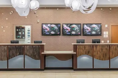 a lobby of a hospital with reception desks and chandeliers at Fairfield Inn Suites by Marriott Orlando At SeaWorld in Orlando