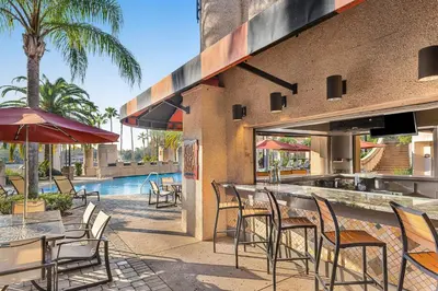 an outdoor patio with tables and chairs and a swimming pool at Marriott's Grande Vista in Orlando