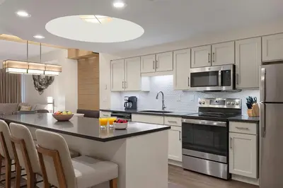a kitchen with white cabinets and a black counter top at Marriott's Imperial Palms Villas in Orlando