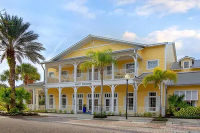a yellow building with palm trees in front of it at Marriott's Harbour Lake in Orlando