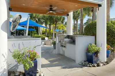 a patio with potted plants and a table with a fan at Marriott's Royal Palms in Orlando