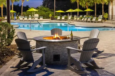 a fire pit with three chairs and a bottle of wine at Marriott's Sabal Palms in Orlando