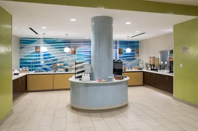 a large kitchen with a counter in a cafeteria at SpringHill Suites by Marriott Orlando at SeaWorld in Orlando
