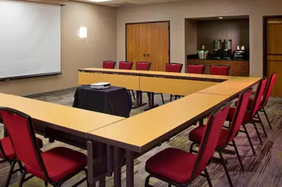a conference room with wooden tables and red chairs at Courtyard Orlando International Drive/Convention Center in Orlando